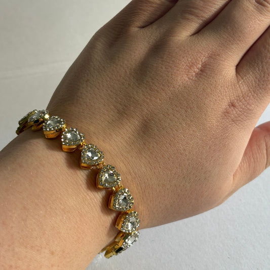 Hand wearing a diamond bracelet on a plain background

