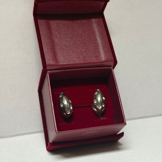 Two silver earrings in a red box on a white background

