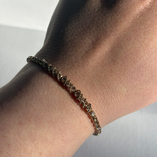 Close-up of a wrist wearing a bracelet against a neutral background

