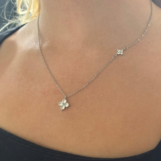 Necklace with a floral pendant on a person's neck against a dark background

