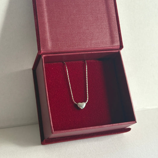 Silver necklace in a red jewelry box on a white background

