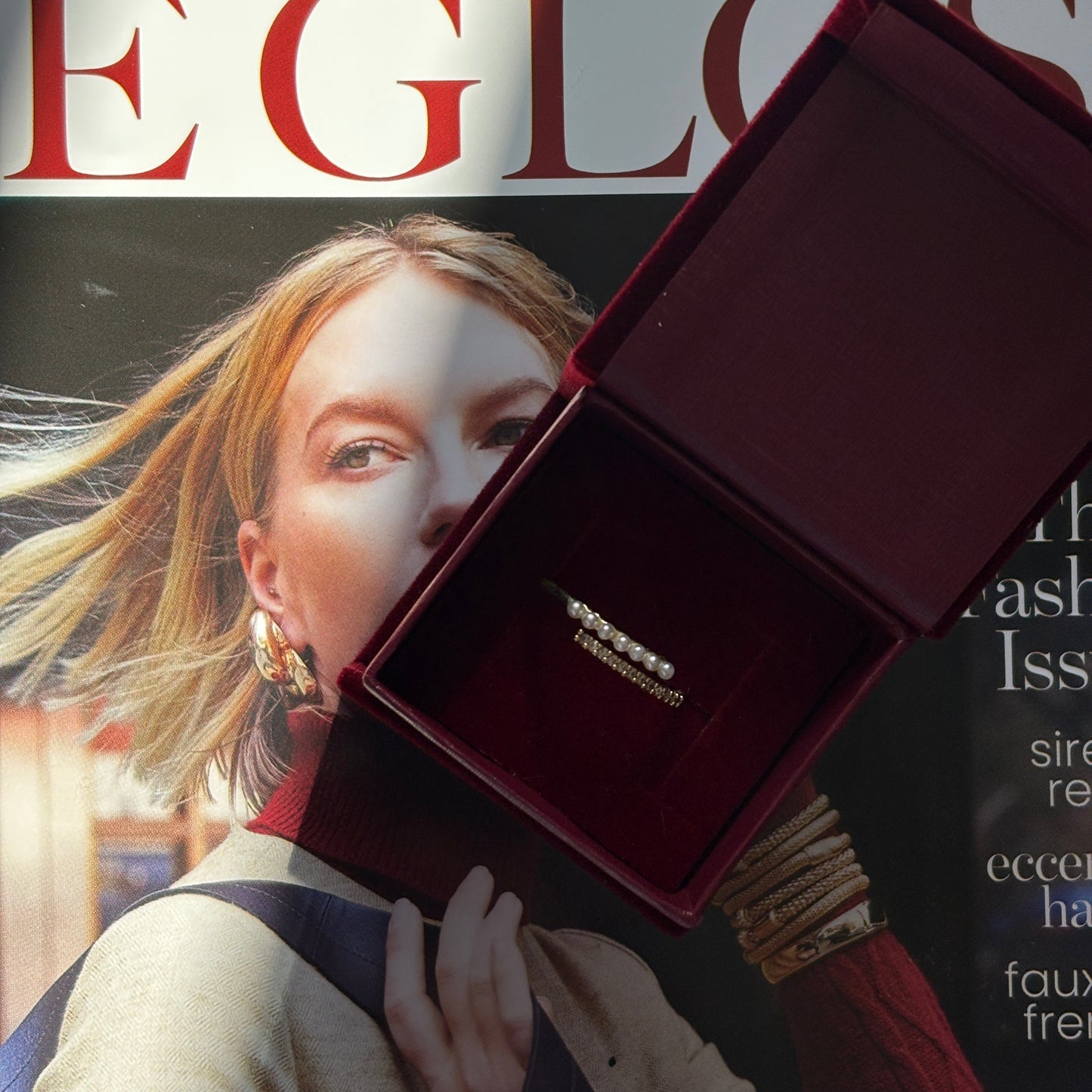 Open jewelry box with a ring on a magazine cover

