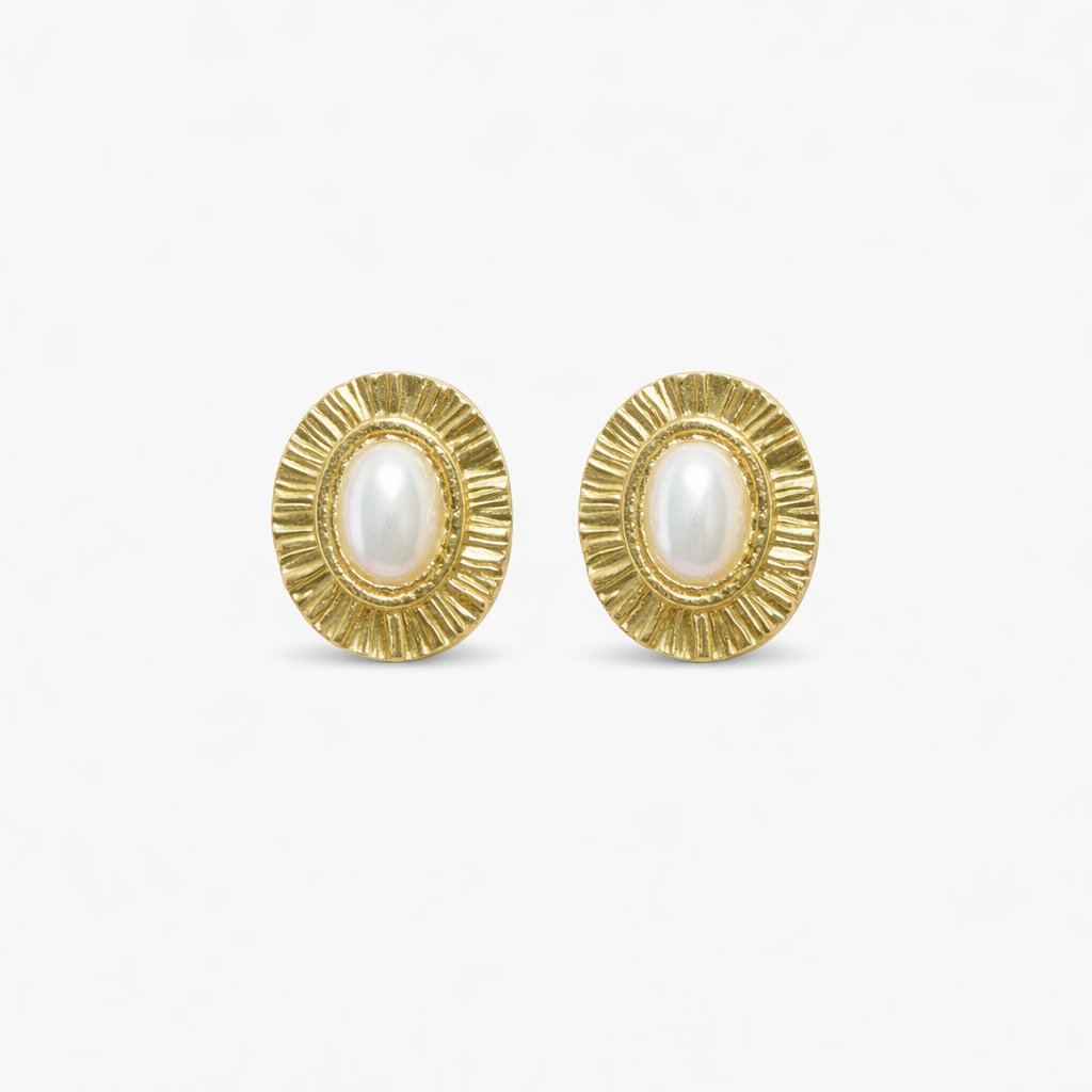 Gold earrings with pearl centres on a white background

