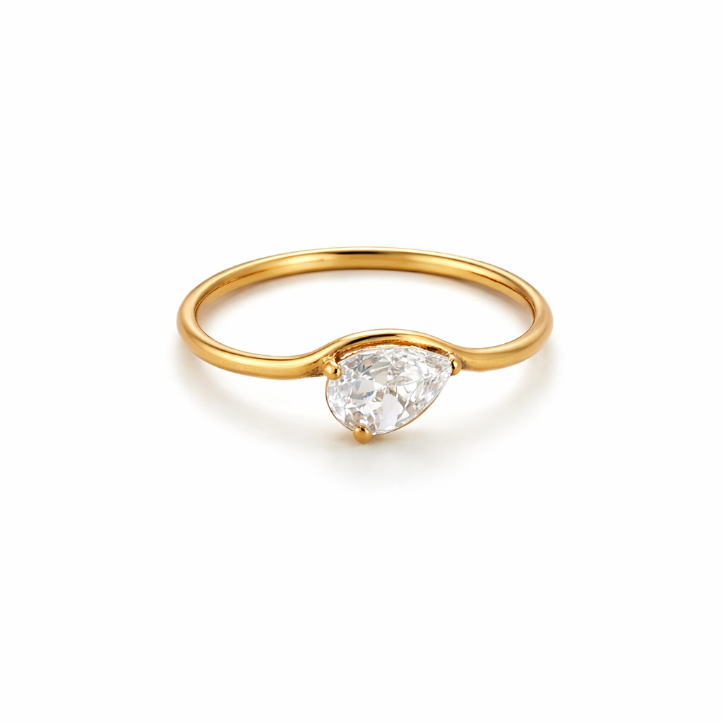Gold ring with a pear-shaped diamond on a white background

