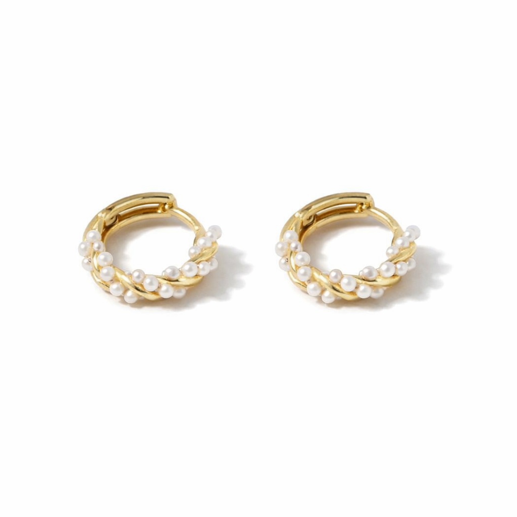 Pair of gold hoop earrings with pearl accents on a white background

