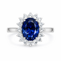 Ring with a blue gemstone and diamond-studded halo on a white background