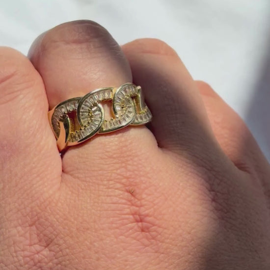 Gold ring with red gemstones in a red jewelry box on a white surface

