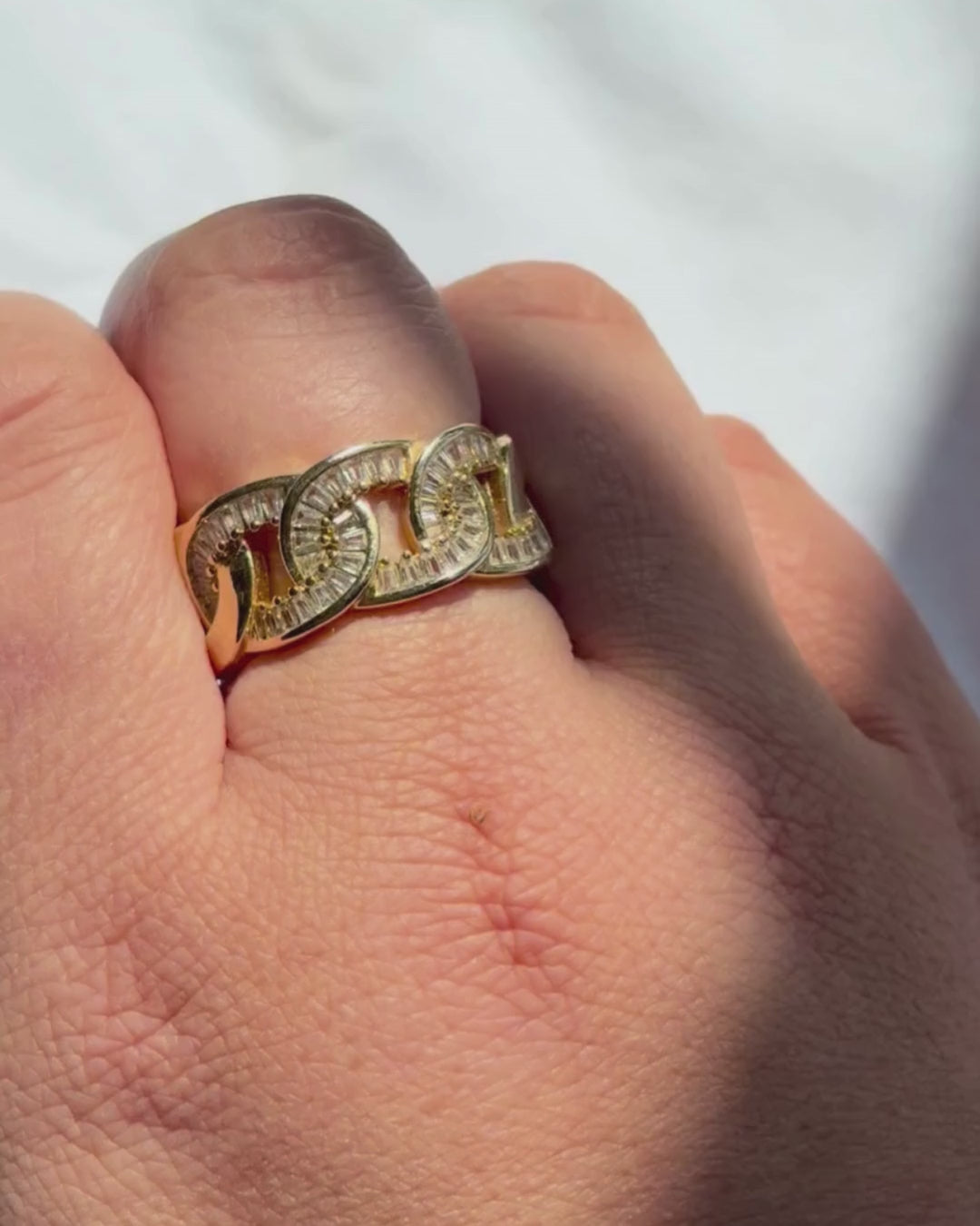 Gold ring with red gemstones in a red jewelry box on a white surface


