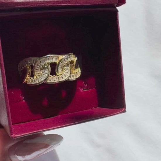 Gold ring with red gemstones in a red jewellery box on a white surface

