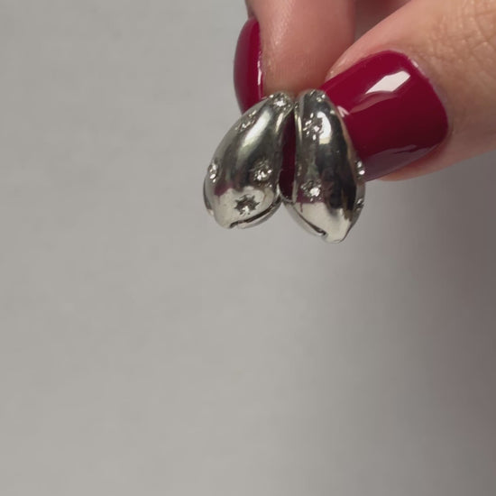 Two silver spoons in a hand. 