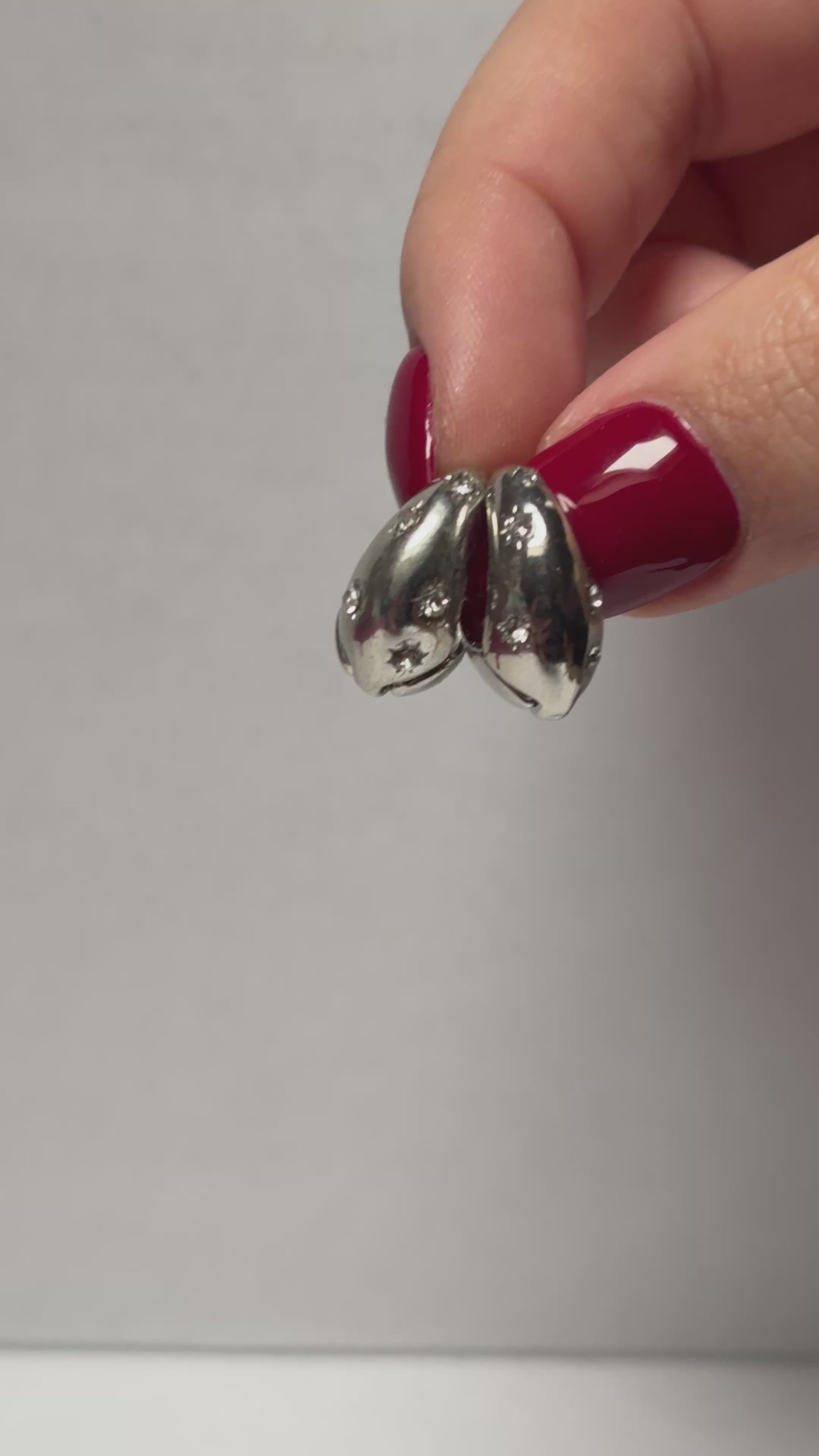 Two silver spoons in a hand. 